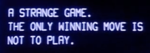 Screenshot from the movie War Games with the text A STRANGE GAME. THE ONLY WINNING MOVE IS NOT TO PLAY.